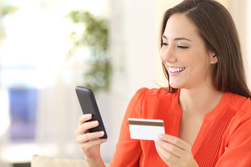 Woman using a credit card to make online purchase.